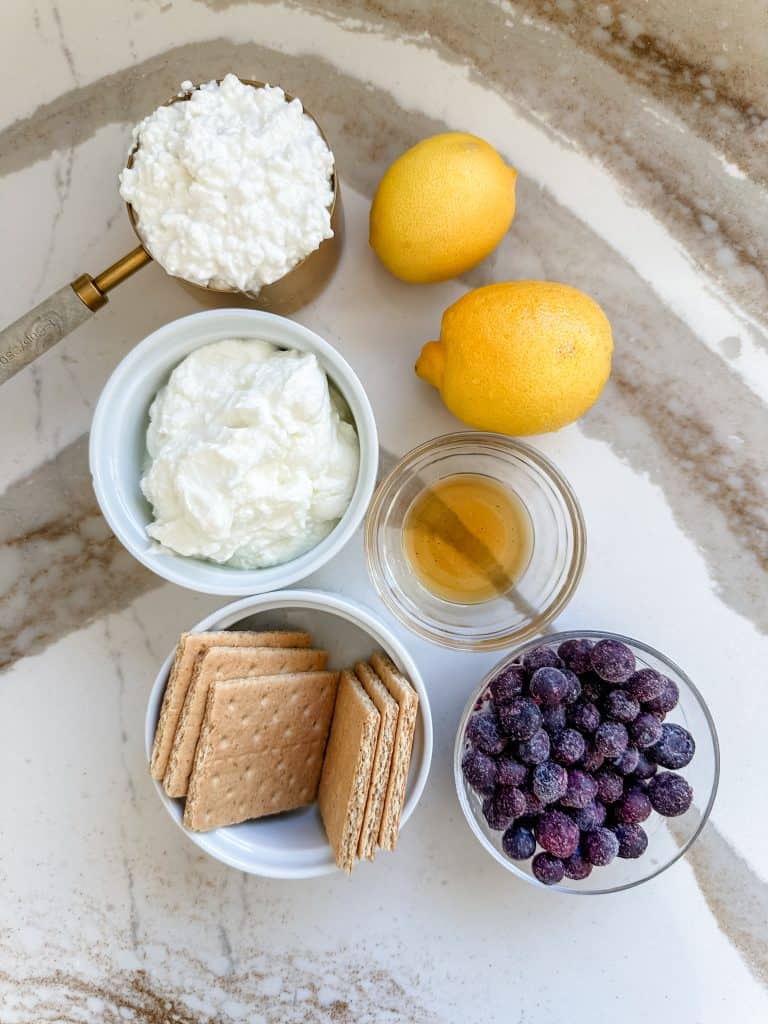all the ingredients you need to make these cheesecake jars in individual containers